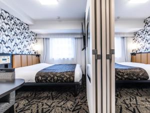 Postel nebo postele na pokoji v ubytování APA Hotel Shin Osaka Minamikata Ekimae