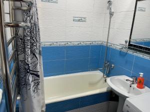 a bathroom with a white tub and a sink at Three rooms Apartment with all facilities in Tashkent
