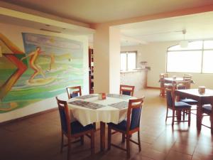 Un comedor con mesas y sillas y un cuadro. en Hotel Ibaigune, en Murueta