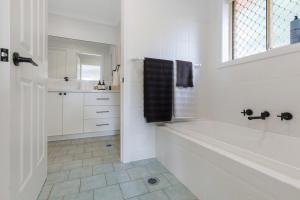 ein weißes Badezimmer mit Badewanne und Waschbecken in der Unterkunft Newly Renovated Cottage sleeps 6 in Lake Albert