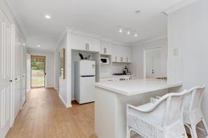 eine weiße Küche mit weißen Geräten und weißen Schränken in der Unterkunft Newly Renovated Cottage sleeps 6 in Lake Albert