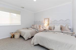 ein weißes Schlafzimmer mit zwei Betten und einem Fenster in der Unterkunft Newly Renovated Cottage sleeps 6 in Lake Albert