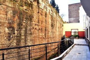 uma grande parede de tijolos com uma cerca ao lado de um edifício em Sevillarent em Sevilha