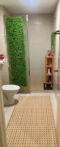 a bathroom with a green wall next to a toilet at Z&A CozyHome -Homestay in Seksyen 13, Shah Alam, MSU, AEON Mall in Shah Alam