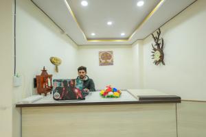 a man sitting at a counter in a room at Mystic Hills Retreat in Shimla