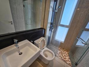 a bathroom with a toilet and a sink and a shower at Modern Family Suites 3 bedroom in Melaka +6 photos