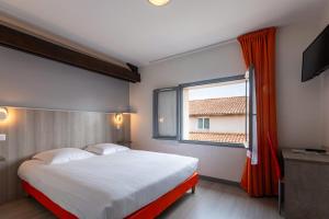 a bedroom with a large bed and a window at Hôtel Le Cheval Blanc in Saint-Maixent-lʼÉcole