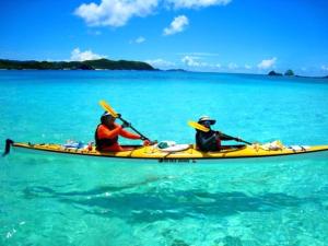 two people in a yellow kayak in the water at Cha Villa in Zamami