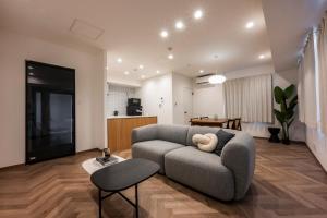 GIVE Meidaimae في طوكيو: غرفة معيشة بها أريكة وطاولة