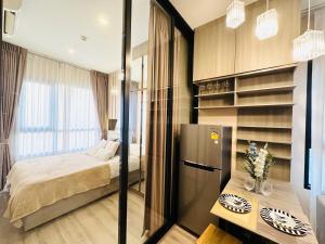 a bedroom with a bed and a refrigerator in a room at Modern condo nr BTS ONNUT WIFI with workroom in Bangkok +21 photos