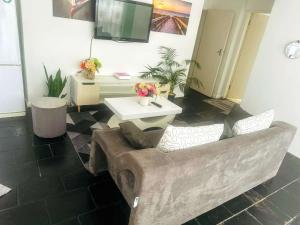 Una sala de estar con un sofá y un televisor. en BotsDiva AIR, en Johannesburgo