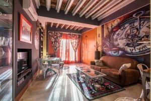 SevillaHome- Ave Cesar في إشبيلية: غرفة معيشة مع ساعة كبيرة على الحائط