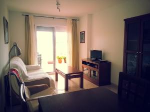 a living room with a tv and a chair and a table at Salinas de Veras in Vera