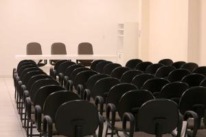 a row of chairs in an empty room at Tri Hotel Xanxerê in Xanxerê