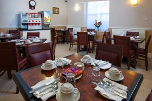 un comedor con mesas y sillas en un restaurante en Dover Hotel - B&B en Londres