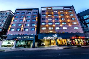 a building on a city street with buildings at Jungmoon City Hotel in Seogwipo