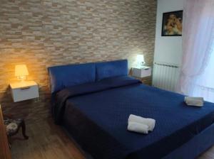 Un dormitorio con una cama azul con dos toallas encima. en Bombana Beach - Vicino, en Fontane Bianche