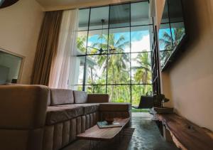 a living room with a couch and a large window at VODA Hotel in Galle