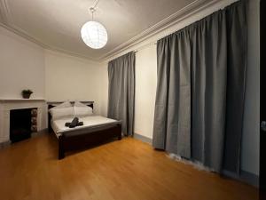 a bedroom with a bed and a large window at Grove Rooms 2 in London