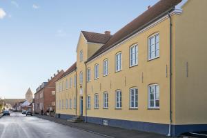un edificio giallo sul lato di una strada di Hotel Residens Møen a Stege