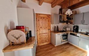 a kitchen with white cabinets and a wooden floor at FeWo BergZeit auf 1000 m Höhe mit Balkon, Parkplatz, WLAN, Küche in Wertach