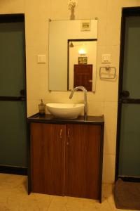 a bathroom with a sink and a mirror at Gardan 2BHK Villa Alibaug in Alibaug +26 photos