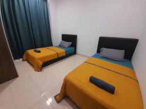 two beds in a room with yellow and blue at Homestay As Sofiyya 1 in Sungai Petani