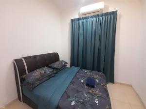 a bedroom with a bed with a green curtain at Homestay As Sofiyya 1 in Sungai Petani