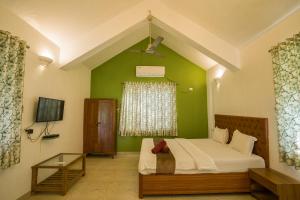 a bedroom with a bed and a green wall at Gardan 2BHK Villa Alibaug in Alibaug