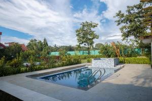 a swimming pool in the middle of a yard at Gardan 2BHK Villa Alibaug in Alibaug