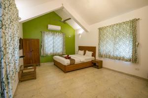 a bedroom with a bed and green walls at Gardan 2BHK Villa Alibaug in Alibaug