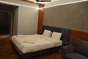 a bedroom with a bed and a chair in it at Hotel Christo's in Velānganni