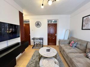 a living room with a couch and a table at Tranquil Luxury Stay, Utawala, JKIA View in Nairobi