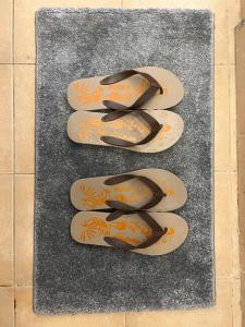 a group of four sandals sitting on a rug at Tranquil Luxury Stay, Utawala, JKIA View in Nairobi