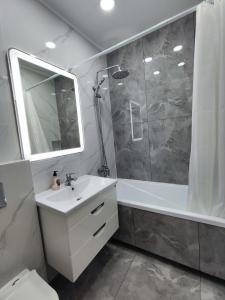 a bathroom with a sink and a shower and a mirror at 2-х комнатная квартира in Kokshetau