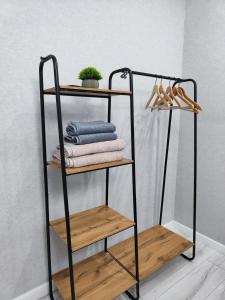 a black towel rack with towels and wooden shelves at 2-х комнатная квартира in Kokshetau