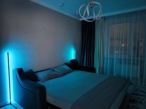 a bedroom with a bed with blue lights on it at 2-х комнатная квартира in Kokshetau
