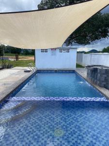 a large swimming pool with a pavilion over it at D'Padang KB Homestay in Kuala Berang
