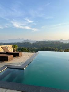 ein Schwimmbad mit Blick auf die Berge in der Unterkunft Sylvan Retreat - Luxury Mountain Cottages in Vagamon