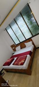 a bedroom with a bed with two large windows at Hotel Maharana Palace in Maheshwar