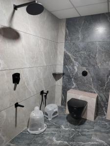 a bathroom with a black toilet and a sink at Hotel Amrutam And Guest House in Tharād
