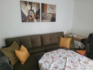 a living room with a brown couch with pillows at i24rooms in Legau