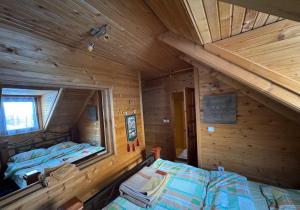 an attic bedroom with two beds in a log cabin at Vikendice Biocinovici in Kolašin