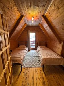 a bedroom with two beds in a wooden cabin at Vikendice Biocinovici in Kolašin