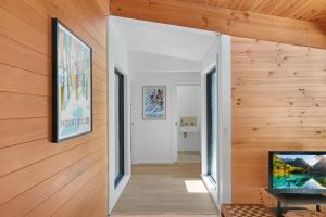 a hallway with wood paneling and a flat screen tv at Hil & Jack's Riverfront Cabin, Merrijig Mt Buller in Merrijig