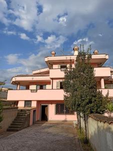 a pink building with a tree in front of it at Villa oasi verde in Rome +42 photos