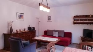 a living room with a red couch and a tv at Fuchs in Eslohe