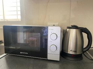 a microwave and a coffee pot on a counter at Guest House Laci in Tirana