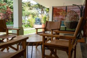 a group of wooden chairs and tables in a room at The Green House in Arusha
