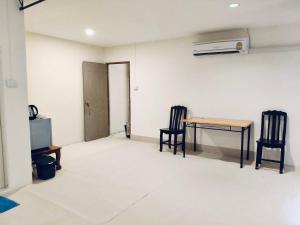 a room with a table and two chairs and a television at Kohchang stayin premium hotel in beach street market in Ko Chang